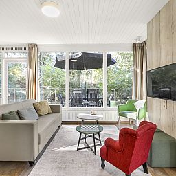 Moderne Sitzecke im 4-Bett-Babybungalow Coldenhove in Eerbeek, Veluwe, mit Blick auf die Terrasse.