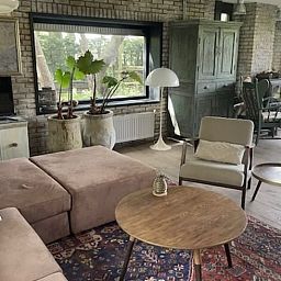 Gemuetliches Wohnzimmer im Ferienhaus in Nijkerk, Veluwe, mit rustikalen Moebeln.