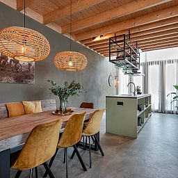 Gezellige eetruimte in Huisje in Veessen, vakantiehuis op de Veluwe, met houten meubels en sfeervolle verlichting.