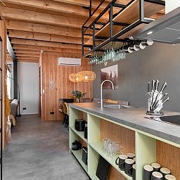 Moderne keuken in Huisje in Veessen, vakantiehuis op de Veluwe, met open planken en strakke inrichting.