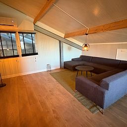 Cozy living room of Holiday Home in Schildwolde, Northeast Groningen, with comfortable corner sofa and modern furnishings.