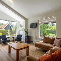 Gezellige woonkamer van GR032 vakantiehuis in Lauwersoog, Groningen met uitzicht op de tuin.