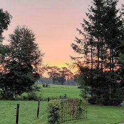 Prachtige zonsondergang bij Huisje in Marum, vakantiehuis in Zuidwest Groningen, omgeven door groen en serene natuur.