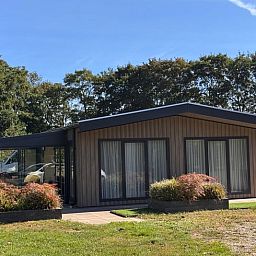 Sonnige Fassade eines Ferienhauses in Weert, Limburg, mit moderner Architektur und viel natuerlichem Licht.
