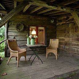 Geniet van de rust op de houten veranda van Huisje in Leudal, een sfeervol vakantiehuis in het groene Leudal, Midden Limburg.