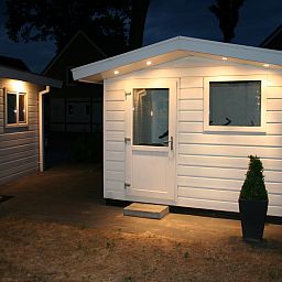 Der beleuchtete Eingang des Chalets in Susteren, Zentral-Limburg, Limburg, strahlt Gastfreundschaft aus.