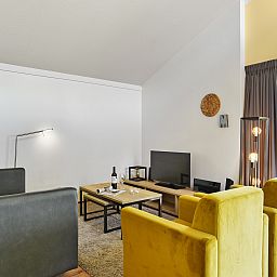 Stijlvolle woonkamer van Landgoed Aerwinkel 4-persoons bungalow 4BL in Posterholt, Limburg, met open keuken en comfortabele zitruimte.