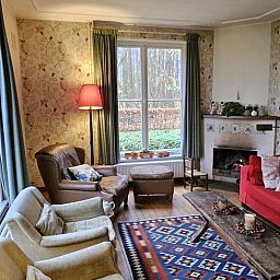 Gemuetliches Wohnzimmer im Ferienhaus in Geijsteren, Nord-Limburg, mit bequemen Sitzgelegenheiten und Kamin.