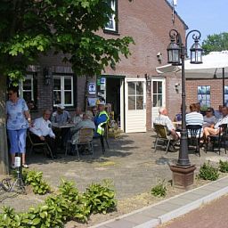 Gezellig terras met parasols bij Appartement Groen, Blauw of Rood in Horst, Noord Limburg, perfect voor ontspanning.