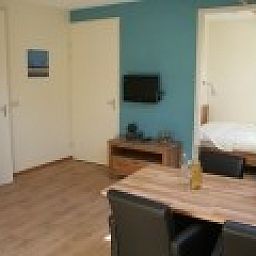 Moderne woonkamer in Appartement Groen, Blauw of Rood in Horst, Limburg met uitzicht op de slaapkamer.