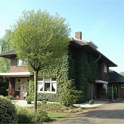 Auenansicht der Ferienvilla Hubertushof, Horst, Nordlimburg, mit grnem Efeu und einem einladenden Weg zum Eingang.