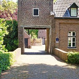 Restful garden at vacation home L185 in Baarlo, North Limburg, surrounded by blooming flowers and green nature.