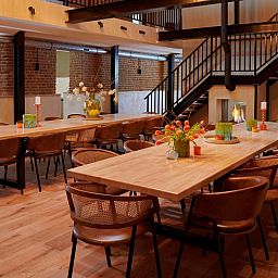 Gemuetliches Wohnzimmer im Ferienhaus in Baarlo, Nord-Limburg. Gemuetliche Sitzecke mit warmer Beleuchtung und modernen Moebeln.