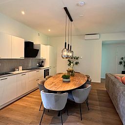 Moderne keuken en eetruimte in Bos Lodge, vakantiehuis voor 8 personen in Maasbree, Noord Limburg. Gezellig interieur met houten tafel.