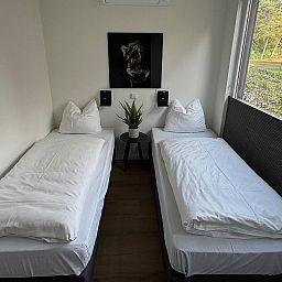 Sfeervolle slaapkamer in Bos Lodge voor 8 personen, vakantiehuis in Maasbree, Noord Limburg, met uitzicht op de groene natuur.