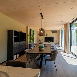 Luxurioese Einrichtung der Bos Villa DeLuxe XL in Maasbree, Nord-Limburg, Ferienhaus mit modernem Wohnzimmer und Blick auf die Terrasse.