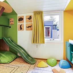 Cozy living room with fireplace in De Lommerbergen 4-person children's bungalow, Reuver, North Limburg. Perfect for family time.