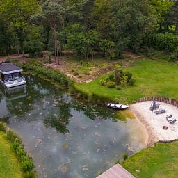 Luftaufnahme eines Ferienhauses in Merselo, Nord-Limburg, mit Teich und gruener Umgebung.