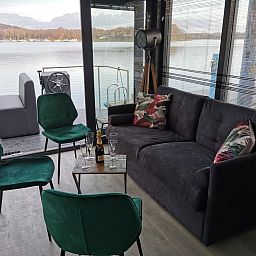 Gemuetliches Wohnzimmer von Floating in Limburg - hot tub, ein Ferienhaus auf dem Wasser in Middelaar, Nord-Limburg mit Blick auf den See.