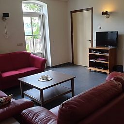 Gezellige woonkamer in Vakantiehuis in Mechelen, Zuid Limburg met comfortabele banken en uitzicht op de groene omgeving.