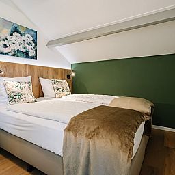 Knusse slaapkamer met kunst aan de muur in Vakantiehuis in Gulpen, Zuid Limburg.