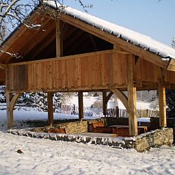 Vacation home in Vijlen, South Limburg, with an attractive wooden veranda in a snowy setting for a cozy winter experience.