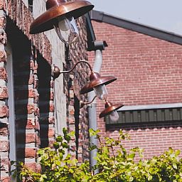 Koperen buitenlampen sieren het vakantiehuis in Scheulder, Zuid Limburg.