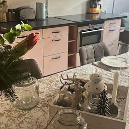 Cozy dining room in vacation home in Beutenaken, South Limburg, with attractive decorations and modern kitchen facilities.