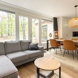 Gezellige woonkamer van Bungalow 4 in Vlierden, De Peel, Noord Brabant met uitzicht op de groene natuur vanuit de comfortabele zithoek.