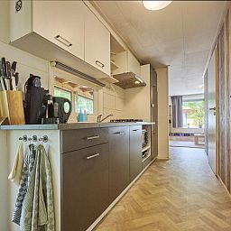 Moderne keuken in 't Heische Hofje, vakantiehuis in Zeeland, De Peel, Noord-Brabant, met uitzicht op de lichte woonkamer.