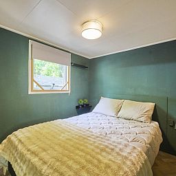 Gezellige slaapkamer in 't Heische hofje, vakantiehuis in Zeeland, De Peel, Noord Brabant, met comfortabel bed en uitzicht op de natuur.