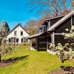 Vakantieverblijf in De Rips, Noord Brabant, met bloeiende bomen en serene omgeving.