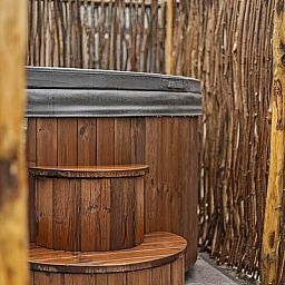 Wooden hot tub at Bosvlucht 6 people Wellness vacation home in Lage Mierde, perfect for relaxation.