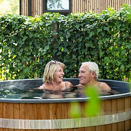 Enjoy the relaxing hot tub at vacation home Berkenhof in Lage Mierde, Kempen, North Brabant, surrounded by green nature.