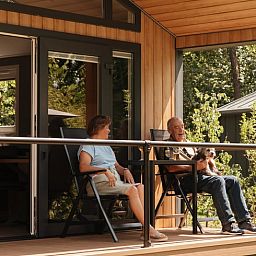 Geniessen Sie die Ruhe auf der Veranda von Huisje in Bergeijk, einem Ferienhaus in der gruenen Umgebung von Kempen in Nordbrabant.