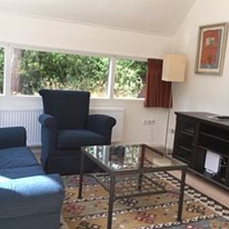 Cozy living room of cottage in Eersel, North Brabant, with comfortable seating and views of the green nature of the Kempen.