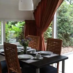 Cozy dining room in Holiday home in Eersel, North Brabant overlooking the green garden, ideal for a relaxing stay.
