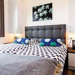 Gezellige slaapkamer in Z Module 6 personen Wellness, Cromvoirt, met kunst aan de muur en veel natuurlijk licht.