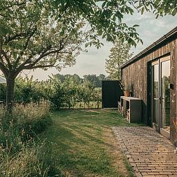 Rustic garden at Holiday home in Chaam, Heart of Brabant with shady spot and landscape views.