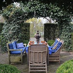 Geniet van de serene tuin met zithoek bij Vakantiehuisje in Sleeuwijk, Hart van Brabant, Noord Brabant.