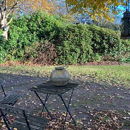 Geniessen Sie den ruhigen Garten des Ferienhauses in Boxtel, Nordbrabant, mit einer rustikalen Terrasse inmitten der ueppigen Natur.