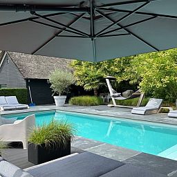 Ontspan bij het zwembad van Huisje in Boxtel, een charmante vakantiewoning in het hart van Noord Brabant, omringd door groen en rust.