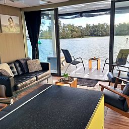 Gemuetliches Wohnzimmer des Ferienhauses in Woudrichem mit Blick auf den Fluss, Nordbrabant.