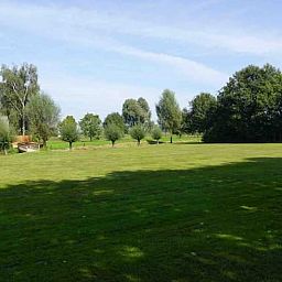Weitlaeufige Wiese bei Ferienhaus in Loon op Zand, umgeben von Baeumen, Herz von Brabant, Nordbrabant.