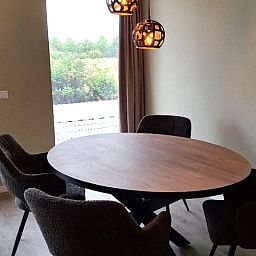 Dining room with round table in Cottage in De Moer, vacation home in North Brabant.