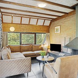 Cozy living room of Bosrand B 6 bungalow in Herpen, Northeast Brabant, with comfortable seating area and views of green nature.