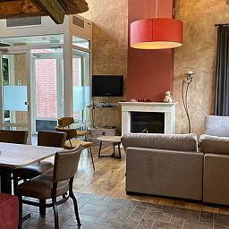 Stijlvolle zithoek met open haard in Vakantiehuis in Schaijk, Noord Brabant, ideaal voor ontspanning.