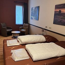 Comfortabele slaapkamer met kunst aan de muur in Vakantiehuis in Schaijk, Noord Brabant.