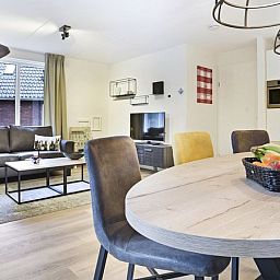 Moderne woonkamer in De Vers 6-persoons kinderbungalow Overloon met eetgedeelte en open keuken.