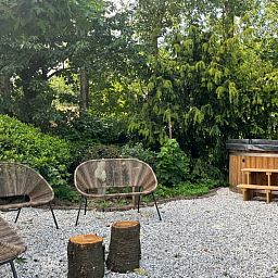 Gezellige zithoek in de tuin van Vakantiehuis in Overloon, omgeven door natuur in Noordoost Brabant.